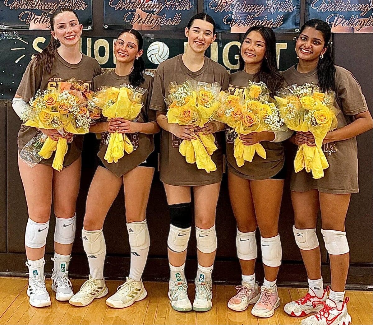 Watchung Hills volleyball seniors hold bouquets on Senior Night.