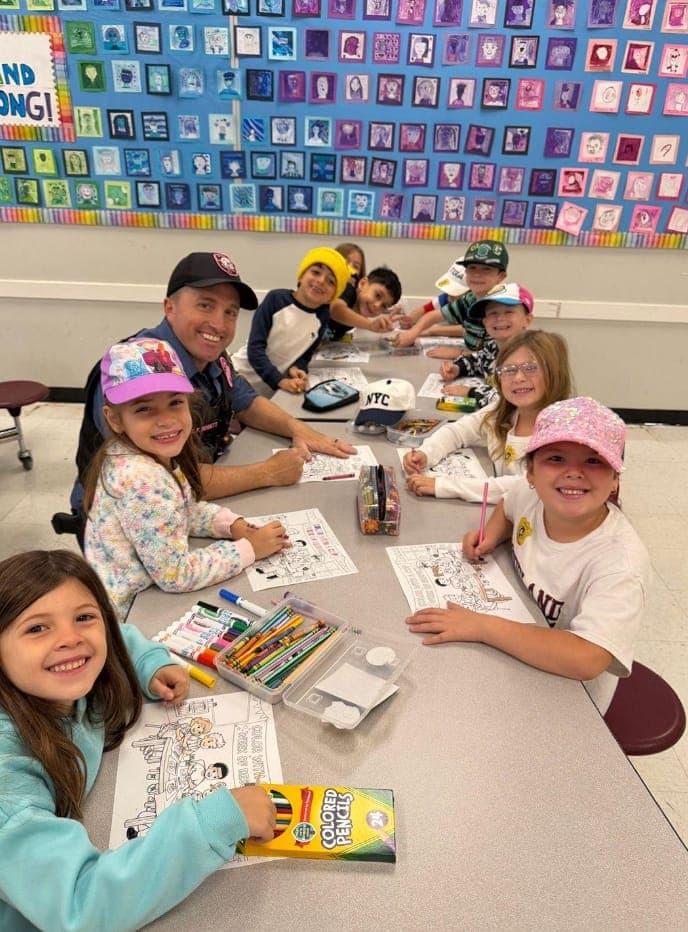 Woodland School first graders share coloring activities and conversation with a Warren Township police officer.